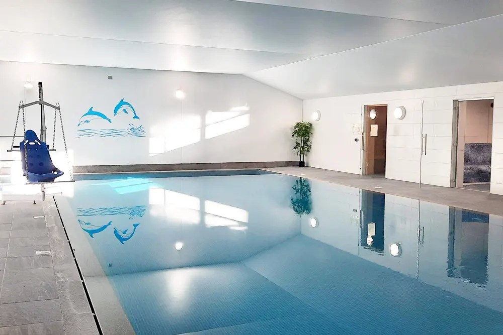 Tranquil indoor swimming pool with hoist and jacuzzi at Wallops Wood